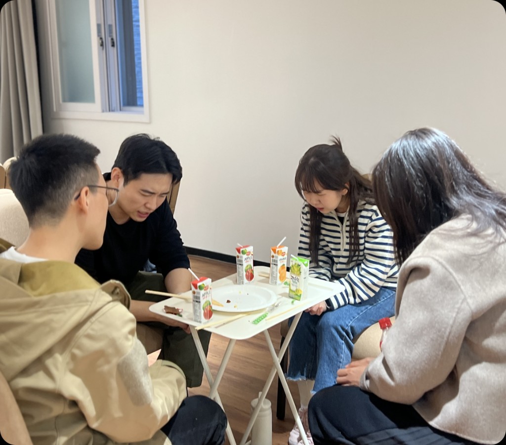 낮은 테이블에 둘러앉은 네 사람
